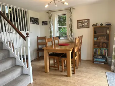 a dining room with a wooden table and chairs at Looe, Cornwall, couples, families, quiet location, views, reliable Wi-Fi, modern cottage in Looe