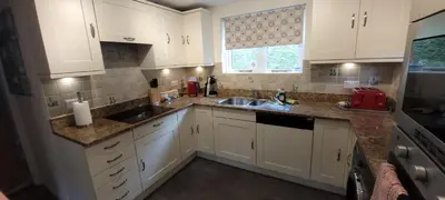a kitchen with white cabinets and a sink and a window at Looe, Cornwall, couples, families, quiet location, views, reliable Wi-Fi, modern cottage in Looe