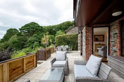 a patio with chairs and a table on a building at Looe, Cornwall, couples, families, quiet location, views, reliable Wi-Fi, modern cottage in Looe