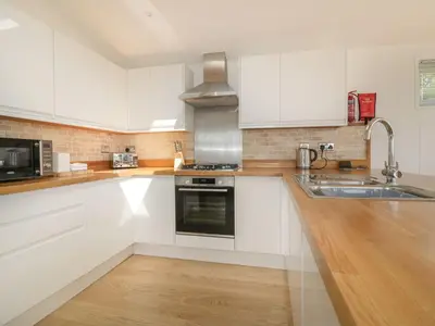 a kitchen with white cabinets and a sink at 2 Faraway Fields in Liskeard