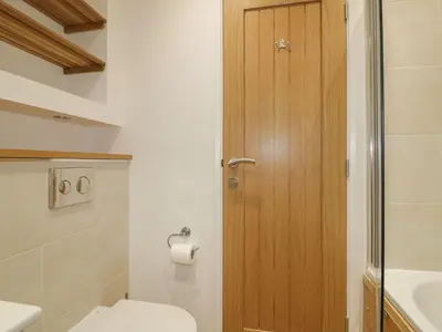 a bathroom with a toilet and a wooden door at 2 Faraway Fields in Liskeard