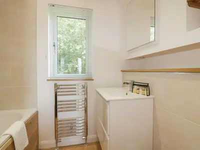 a white kitchen with a sink and a window at 2 Faraway Fields in Liskeard