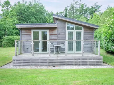 a small cabin with a table on a deck at 5 Faraway Fields in Liskeard