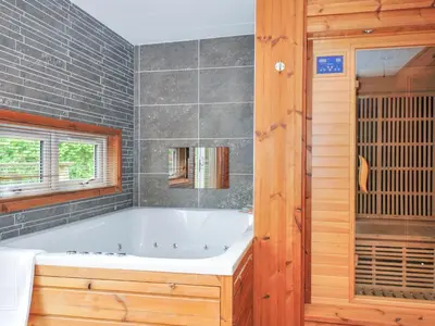a bath tub in a bathroom with a window at 5 Faraway Fields in Liskeard