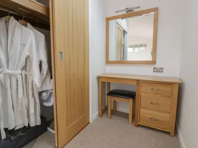 a bathroom with a wooden vanity and a mirror at 11 Faraway Fields in Liskeard