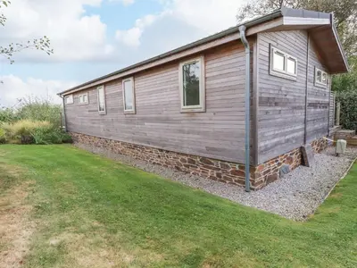 a tiny house on a stone wall with a yard at 15 Faraway Fields in Liskeard