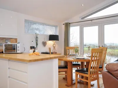 a kitchen and living room with a table and a microwave at 15 Faraway Fields in Liskeard