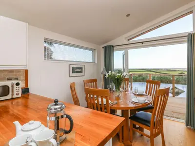a kitchen and dining room with a table and chairs at 14 Faraway Fields in Liskeard