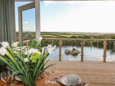 a table with a vase of flowers on a deck at 14 Faraway Fields in Liskeard