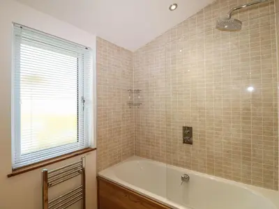 a bathroom with a bath tub and a window at 14 Faraway Fields in Liskeard