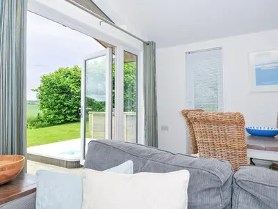 a living room with a couch and a large window at 1 Horizon View in Liskeard