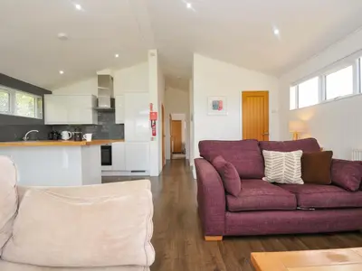 a living room with a purple couch and a kitchen at 3 Horizon View in Liskeard