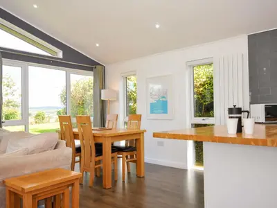 a kitchen and living room with a table and chairs at 3 Horizon View in Liskeard