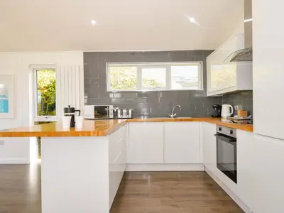 a kitchen with white cabinets and wood counter tops at 3 Horizon View in Liskeard
