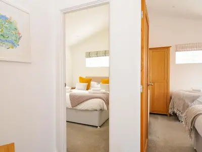 a bedroom with two beds and a mirror at 3 Horizon View in Liskeard