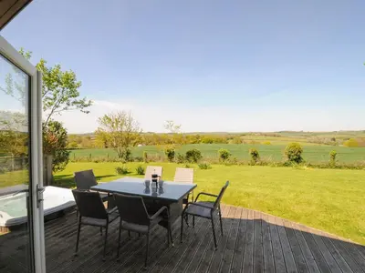 a table and chairs on a patio with a view of a field at 4 Horizon View in Liskeard
