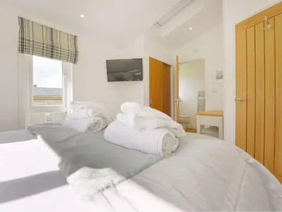 a white bed with towels on top of it at 4 Horizon View in Liskeard