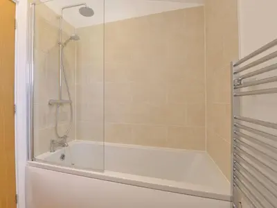 a bathroom with a shower with a white bath tub at 4 Horizon View in Liskeard