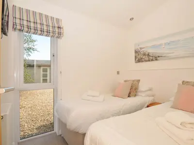 two beds in a room with a window at 8 Horizon View in Liskeard