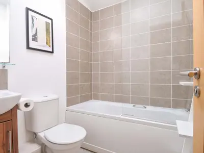 a bathroom with a toilet and a tub and a sink at 8 Horizon View in Liskeard