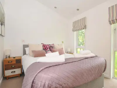 a bedroom with a large bed and a window at 8 Horizon View in Liskeard
