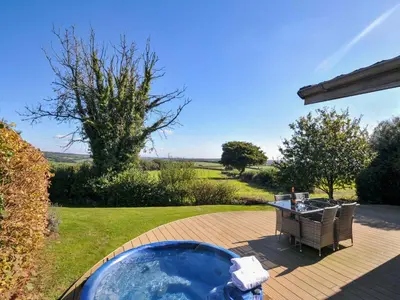 a jacuzzi tub on a patio with a table at 10 Horizon View in Liskeard