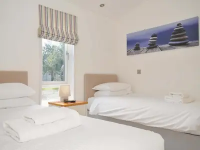 a room with two beds and a window at 10 Horizon View in Liskeard