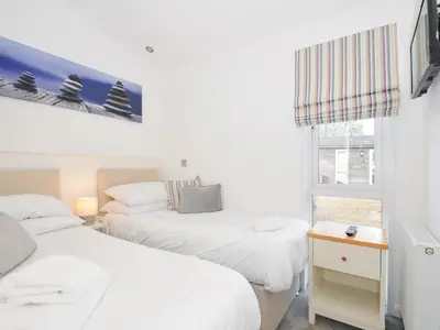a bedroom with two beds and a window at 9 Horizon View in Liskeard