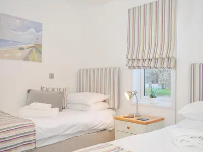 a bedroom with two beds and a window at 9 Horizon View in Liskeard