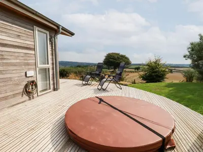 a wooden deck with a table and chairs on a house at 11 Horizon View in Liskeard