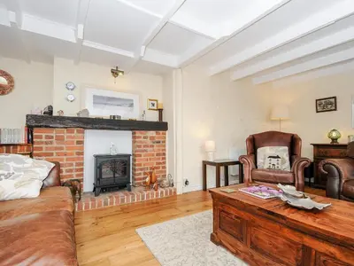a living room with a couch and a fireplace at Church View Cottage in Looe