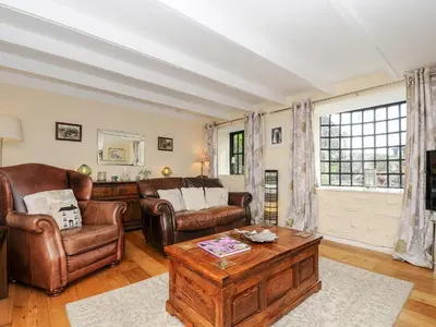 a living room with leather chairs and a coffee table at Church View Cottage in Looe