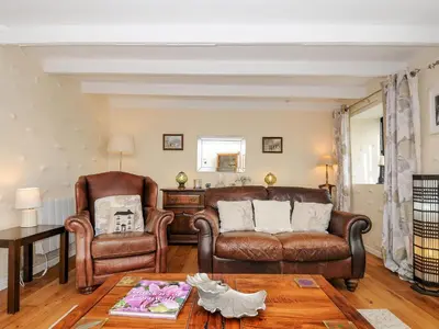 a living room with a couch and two chairs at Church View Cottage in Looe