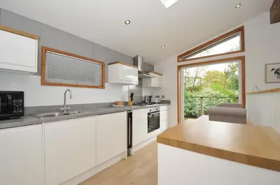 a kitchen with white cabinets and a counter top at 3 Southern Place in Liskeard
