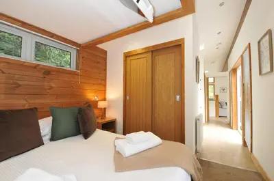 a bedroom with a bed and a wooden wall at 3 Southern Place in Liskeard