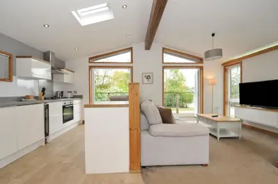 a living room with a couch and a kitchen at 3 Southern Place in Liskeard