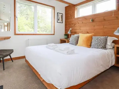 a bedroom with a large white bed and two windows at 6 Southern Place in Liskeard