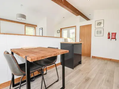 a dining room with a wooden table and chairs at 6 Southern Place in Liskeard