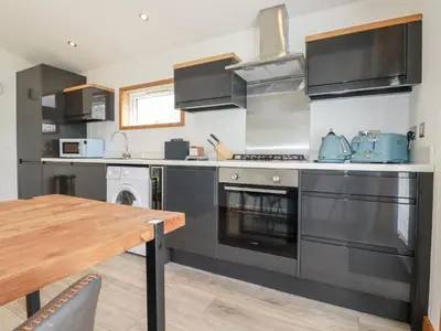 a kitchen with stainless steel appliances and a wooden table at 6 Southern Place in Liskeard