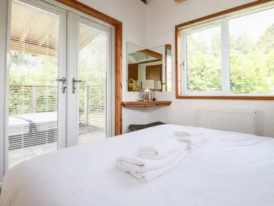 a bedroom with a white bed and a window at 6 Southern Place in Liskeard