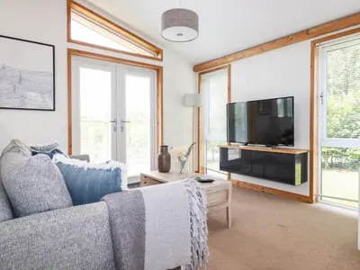 a living room with a couch and a flat screen tv at 6 Southern Place in Liskeard
