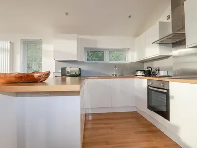 a kitchen with white cabinets and a wooden counter top at 14 Horizon View in Liskeard
