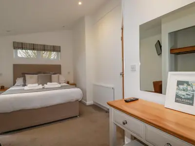 a bedroom with a large bed and a mirror at 14 Horizon View in Liskeard