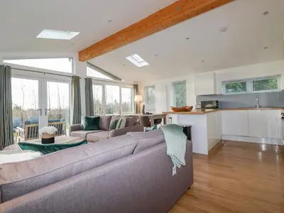 a living room with a couch and a kitchen at 14 Horizon View in Liskeard