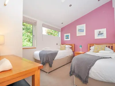 a bedroom with two beds and a purple wall at 15 Horizon View in Liskeard