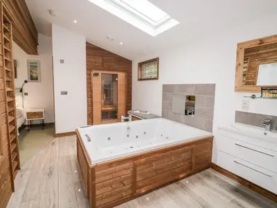 a large bathroom with a large tub and a sink at 2 Meadow Retreat in Liskeard