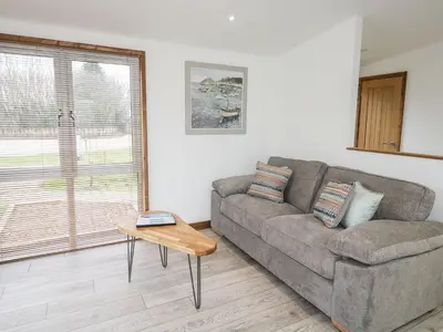 a living room with a couch and a table at 2 Meadow Retreat in Liskeard