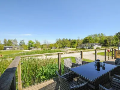 a patio with a table and chairs on a deck at 5 Meadow Retreat in Liskeard