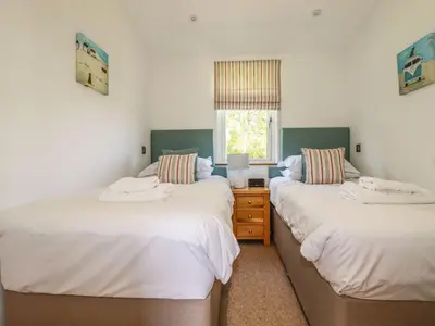 a bedroom with two beds and a window at 5 Meadow Retreat in Liskeard