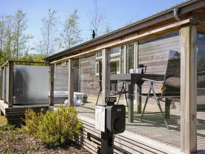 a screened in porch of a house with a table on a deck at 7 Meadow Retreat in Liskeard